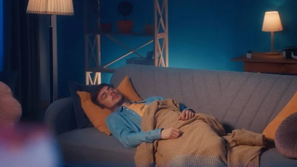 一个疲惫疲倦的穿休闲装的男人睡在客厅的沙发上 上面铺着一条毯子 精力不足 人工作负担过重 白天很辛苦 — 图库照片