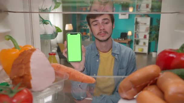 Mężczyzna Pokazuje Smartfona Zielonym Ekranem Kiwa Głową Mężczyzna Stoi Przy — Wideo stockowe