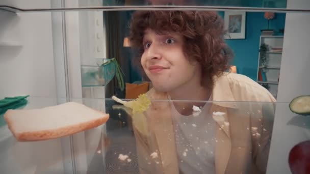 Ein Hungriger Junger Mann Blickt Überrascht Einen Leeren Kühlschrank Betrachtet — Stockvideo