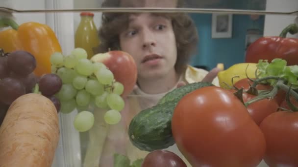 Homme Tient Près Réfrigérateur Ouvert Avec Téléphone Oreille Homme Examine — Video