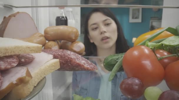 Asiatka Stojí Otevřené Ledničky Zdravými Nezdravými Produkty Žena Pokrčí Rameny — Stock video