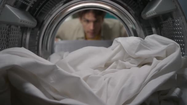 Junger Mann Mit Wäschekorb Öffnet Die Tür Der Waschmaschine Und — Stockvideo