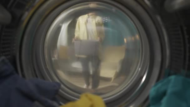 身穿便衣 提着洗衣篮的成年妇女打开洗衣机的门 拿出干净的衣服 她嗅着新鲜的衣服笑了 从洗衣机的内部观看 Hdr — 图库视频影像