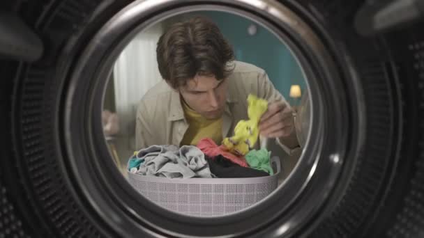 Junger Mann Lässiger Kleidung Mit Einem Wäschekorb Voller Frischer Kleidung — Stockvideo