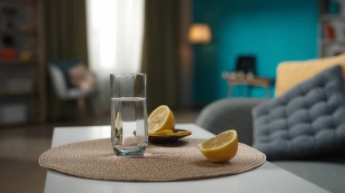 Masanın üzerinde duran su bardağının yakın plan bir resmi, yanında limon ve coşkun bir hap duruyor. Ev hekimliği konsepti. Sağlık hizmetleri reklamı.