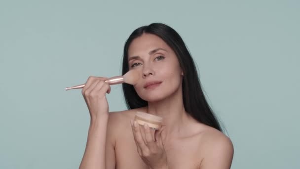 Eine Frau Taucht Einen Make Pinsel Ein Puderglas Pustet Überschüssiges — Stockvideo