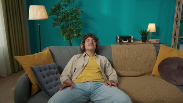 Oturma Odasındaki Kanepede Rahat Rahat Oturan Genç Bir Erkek Modelin — Stok video