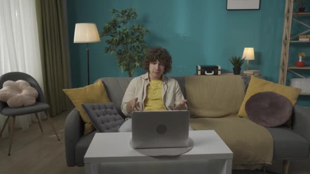 Oturma Odasındaki Kanepede Dizüstü Bilgisayarlı Gündelik Kıyafetlerle Oturan Genç Bir — Stok video