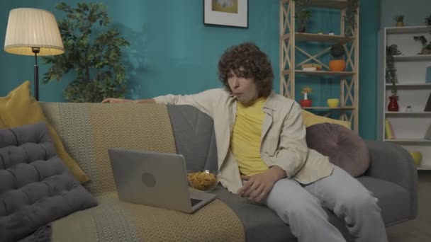 거실에서 캐주얼 모델의 클로즈업 초상화 남자는 소파에 노트북에서 영화를 컨셉의 — 비디오