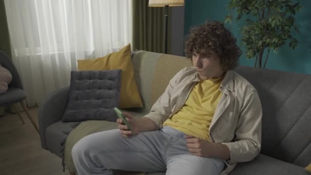 Potret Seorang Pria Muda Ruang Tamu Man Duduk Sofa Memegang — Stok Video