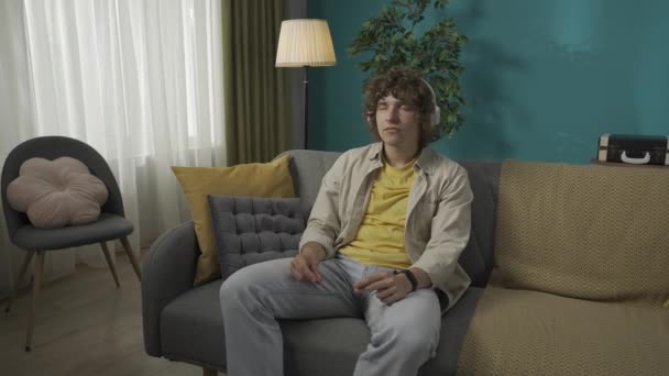 Oturma Odasındaki Kanepede Rahat Rahat Oturan Genç Bir Erkek Modelin — Stok video