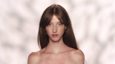 Kafkas modelinin çekici portresi. Kameraya poz veren uzun saçlı ve doğal makyajlı esmer bir kızı yakından çek. Güzellik sigortası reklam konsepti.