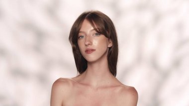 Çekici esmer modelin portresi. Kameraya bakan, uzun saçlı ve doğal makyajlı güzel bir kıza yaklaş. Güzellik ürünleri reklam konsepti.