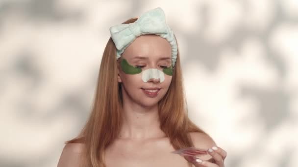 Seorang Wanita Mengeluarkan Tambalan Bibir Merah Dari Paket Dengan Latar — Stok Video