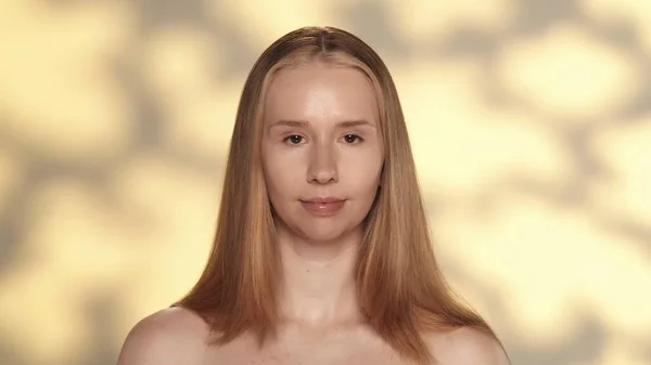 清潔で輝く肌を閉じた若いセミナーの女性の肖像画 ハイライト付きの黄色の背景にあるスタジオのブロンドの女性 化粧品 スキンケアのコンセプト — ストック写真