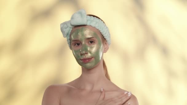 Una Donna Con Una Maschera Cosmetica Verde Sul Viso Dimostra — Video Stock
