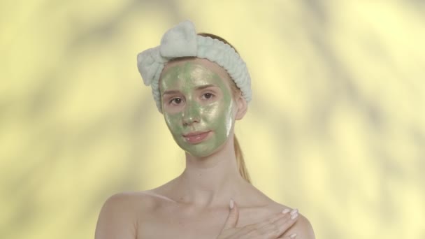 Kvinna Med Grön Kosmetisk Mask Ansiktet Visar Sin Släta Friska — Stockvideo