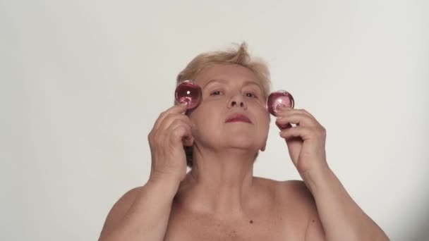 아름다운 여성의 초상화 크로스 스피어 글라스 롤러로 얼굴과 마사지를 만드는 — 비디오