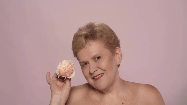 美しい上級女性の肖像画 バラの花を抱えた中年の女性モデルが カメラの笑顔を見つめていた ビューティーボディケアの広告コンセプト — ストック写真