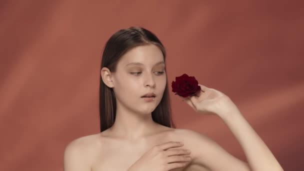 Kobieta Zamyka Oko Czerwonym Pączkiem Róży Biegnie Ręką Gołych Ramionach — Wideo stockowe