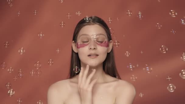 Young Woman Hydrogel Patches Her Eyes Touches Clean Smooth Skin — Stock Video