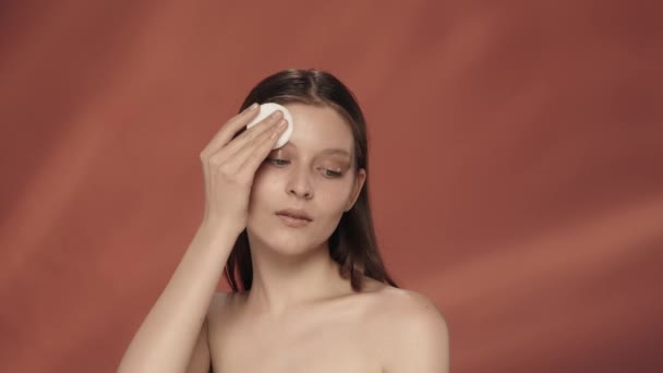 Μια Γυναίκα Φροντίζει Δέρμα Της Στο Στούντιο Κόκκινο Φόντο Από — Αρχείο Βίντεο