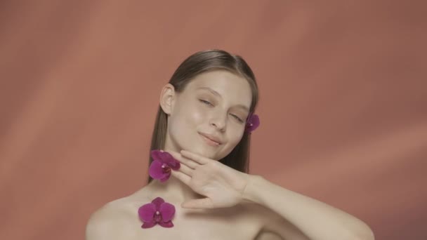 Eine Junge Frau Mit Orchideenblüten Haar Der Nähe Ihres Gesichts — Stockvideo
