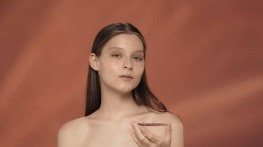 Bir kadın bir paket hidrojel bandı tutuyor. Stüdyoda kırmızı arka planda bir kadın var. Güzellik, kozmetoloji, tedavi ve bakım kavramı