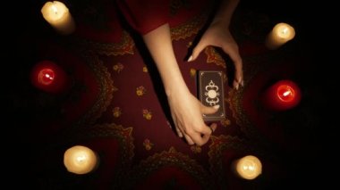 Falcı seansı sahnesi, üst manzara. Tarot kartlarından bir plan yapan bir kadının yakın çekim görüntüsü. Güverteden üç kart seçen ve anlamını açıklayan bir kadın. Esrarengiz kavram.