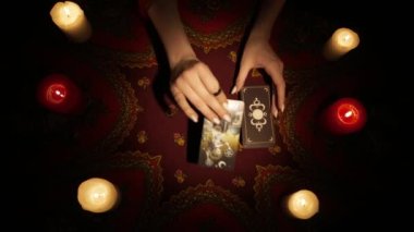 Falcı seansı sahnesi, üst manzara. Güverteden kehanet için bir kaç tarot kartı seçen bir kadının yakın plan fotoğrafını çek ve masanın üzerine koy. Görüntü tarafı görünür. Esrarengiz kavram.