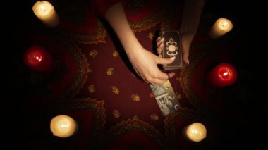 Falcı seansı sahnesi, üst manzara. Güverteden bir sürü kart seçen bir kadının yakın plan fotoğrafını çek ve masanın üzerine bir tarot düzeni çiz ve onları görünür görüntü kenarına yerleştir. Öngörü kavramı.