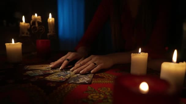 房间里桌子的近景镜头 周围有许多蜡烛 女人从她自己做的桌子上拿走塔罗牌的布局 占卜概念 — 图库视频影像