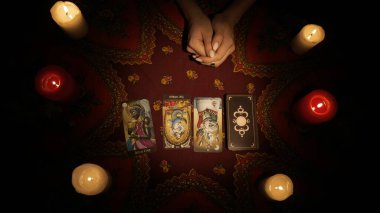 Falcı seansı sahnesi. Bir kadın elinin, müşteriler için masaya tarot kartları yerleştirip kameraya gösterirken yakın plan görüntüsü. Öngörü kavramı.