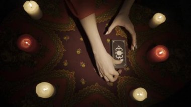 Falcı seansı sahnesi, üst manzara. Tarot kartlarından bir plan yapan bir kadının yakın çekim görüntüsü. Güverteden üç kart seçen ve anlamını açıklayan bir kadın. Esrarengiz bir kavram. HDR BT2020