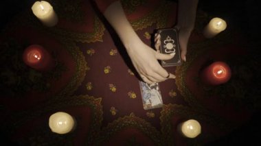 Falcı seansı sahnesi, üst manzara. Bir bayanın el ele tutuşup, elinde bir sürü kart tutarken ve masanın üzerinde bir hayran tarot düzeni oluştururken yakın plan çekimleri. Kehanet kavramı. HDR BT2020
