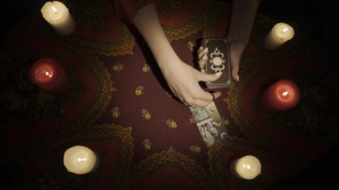 Falcı seansı sahnesi, üst manzara. Güverteden bir sürü kart seçen bir kadının yakın plan fotoğrafını çek ve masanın üzerine bir tarot düzeni çiz ve onları görünür görüntü kenarına yerleştir. Öngörü kavramı