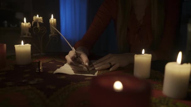 房间里桌子的近景镜头 周围有许多蜡烛 女人拿着漂亮的白毛笔 开始在古旧的纸上写一封信 美学概念 Hdr Bt2020 Hlg Material — 图库视频影像