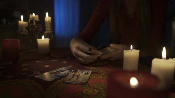 房间里桌子的近景镜头 周围有许多蜡烛 女人从甲板上拿出卡片放在桌上 她正在为自己做塔罗牌布置 占卜的概念 Hdr — 图库视频影像