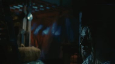 Korku filmi sahnesi. Yakın çekim, kadın yüzüne odaklan. Korkak sarışın manken, eski depodaki varilin arkasındaki adamdan saklanan korkunç manyağın kurbanı. Etrafına bakıyor, çok korkmuş..