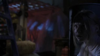 Korku filmi sahnesi. Yakın çekim, kadın yüzüne odaklan. Korkak sarışın manken, eski depodaki varilin arkasında saklanan korkunç manyağın kurbanı. Elektrikli testereli bir adam etrafta dolaşıyor, bakıyor.