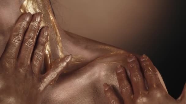 ゴールドシマーで覆われた女性モデルの肩と襟のエリアのクローズアップショット 女性は流れている黄金の液体塗料をこすります 美容広告コンセプト スローモーション — ストック動画