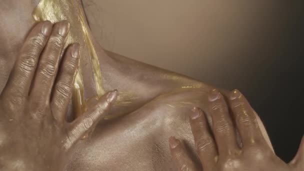 ゴールドシマーで覆われた女性モデルの肩と襟のエリアのクローズアップショット 女性は流れている黄金の液体塗料をこすります 美容広告コンセプト スローモーション Hdr Bt2020について — ストック動画