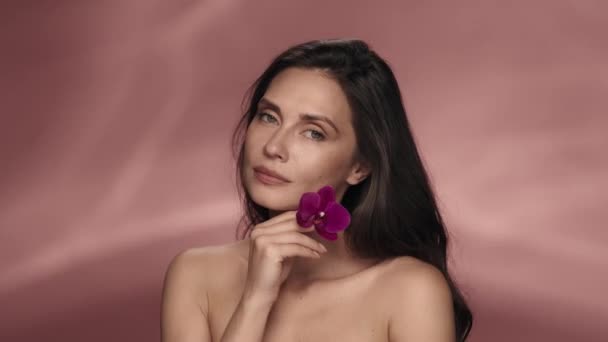 Uma Mulher Atraente Seminude Toca Uma Flor Orchid Seu Rosto — Vídeo de Stock