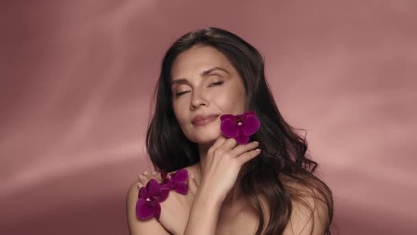 Retrato Uma Mulher Seminua Com Flores Orquídeas Roxas Suas Mãos — Vídeo de Stock