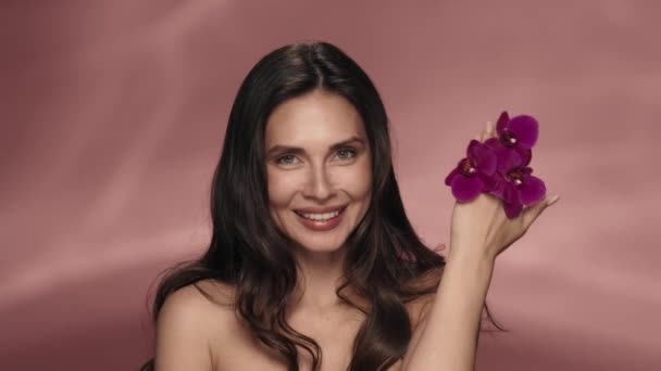 Vrouw Verwijdert Haar Hand Met Orchidee Bloemen Van Haar Gezicht — Stockvideo