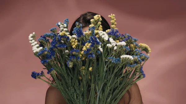 Bir Kadın Yüzünü Bir Buket Kır Çiçeğinin Arkasına Saklar Derisi — Stok fotoğraf