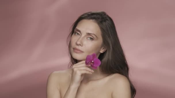 Atrakcyjna Kobieta Dotyka Jej Twarzy Kwiatem Orchidei Zakrywa Nią Oko — Wideo stockowe