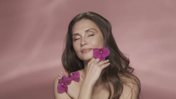 Retrato Uma Mulher Seminua Com Flores Orquídeas Roxas Suas Mãos — Vídeo de Stock