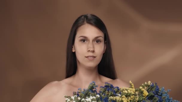 Женщина Букетом Диких Цветов Демонстрирует Идеальную Кожу Лица Семисторонняя Женщина — стоковое видео
