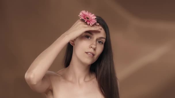 Bir Kadın Yüzüne Boynuna Omuzlarına Pembe Bir Gerbera Çiçeğiyle Dokunuyor — Stok video